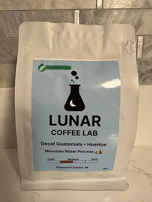 Lunar Coffee Lab Decaf Guatemala HueHue, 8oz, in a white pouch with a pale blue label and the moon-and-flask mark.