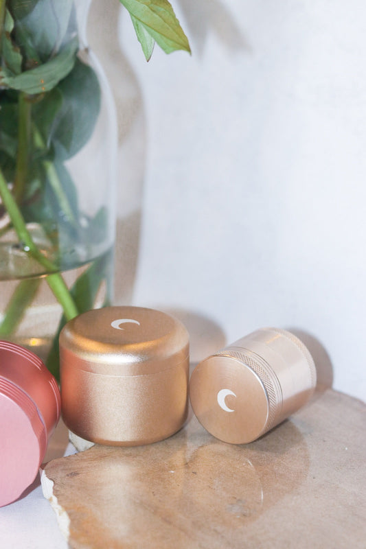 Rose gold stash jars styled with soft greenery on a light background