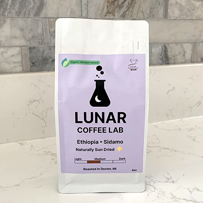 Lunar Coffee Lab Ethiopia Sidamo in a white pouch with a lavender label and the moon-and-flask mark, on a marble counter.