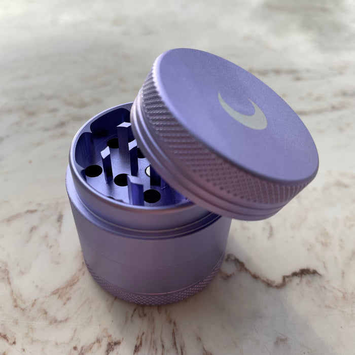 Brando Moon 1.6 inch crusher in matte purple, lid off, on marble