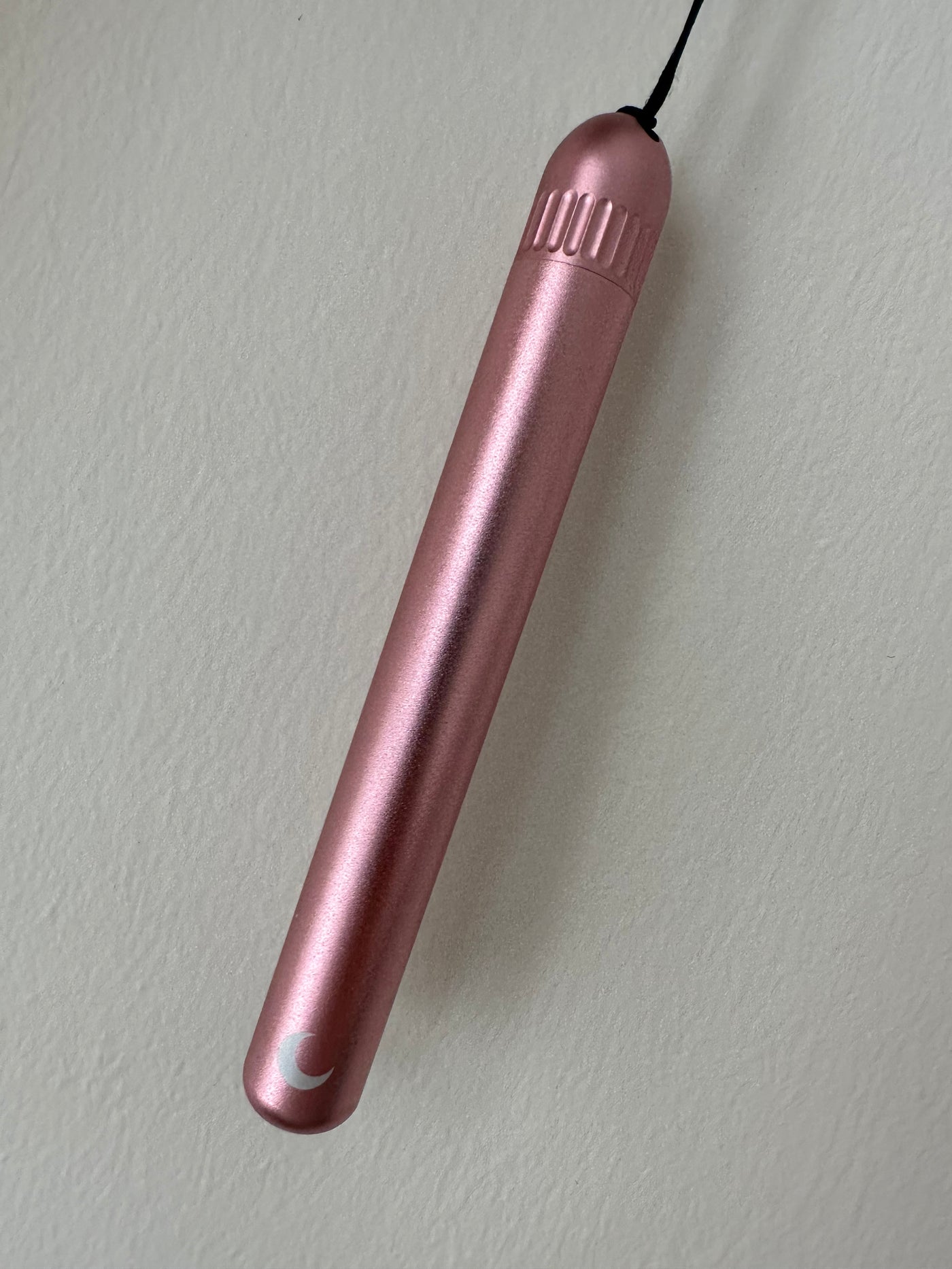 Rose-pink anodised metal tube with a ribbed screw cap, keychain cord and white moon mark.