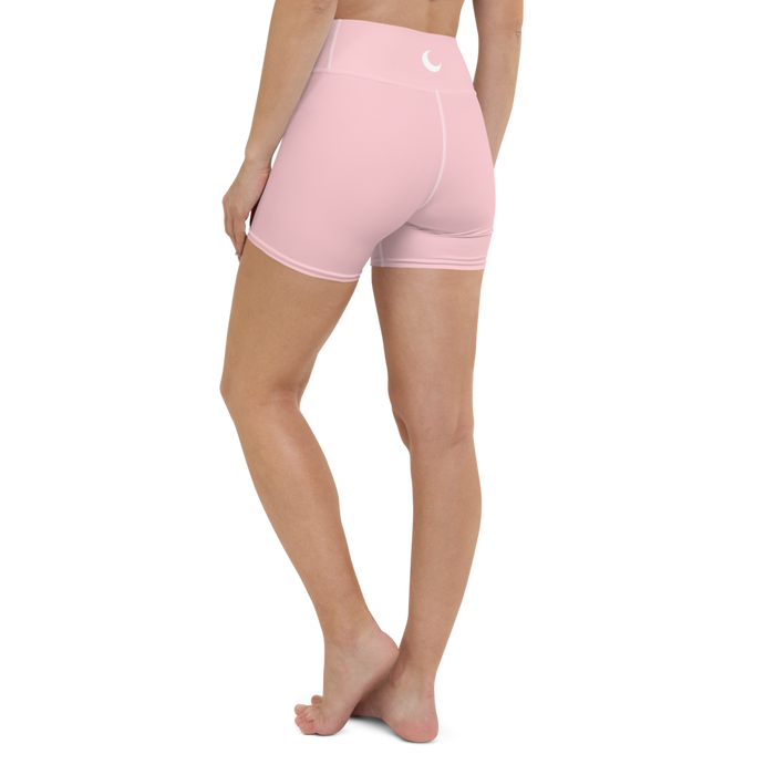 Blush pink high-waist yoga shorts worn back-to-camera, with a white crescent moon at the waistband.
