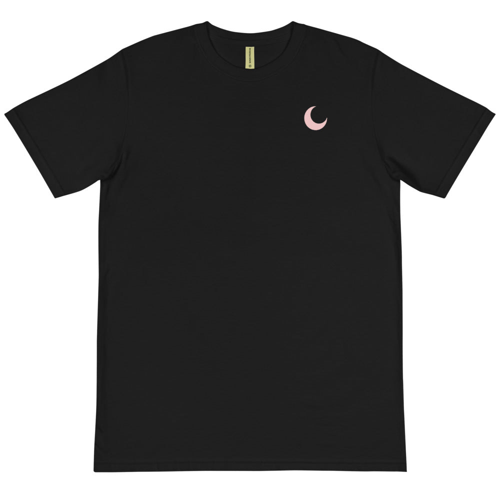 Black organic cotton tee laid flat, with a small blush crescent moon embroidered at the chest.