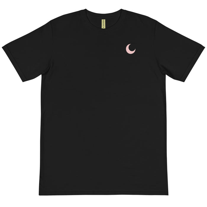 Black organic cotton tee laid flat, with a small blush crescent moon embroidered at the chest.