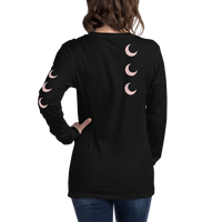 Black long sleeve tee worn back-to-camera, with blush crescent moons falling down the spine and one sleeve.
